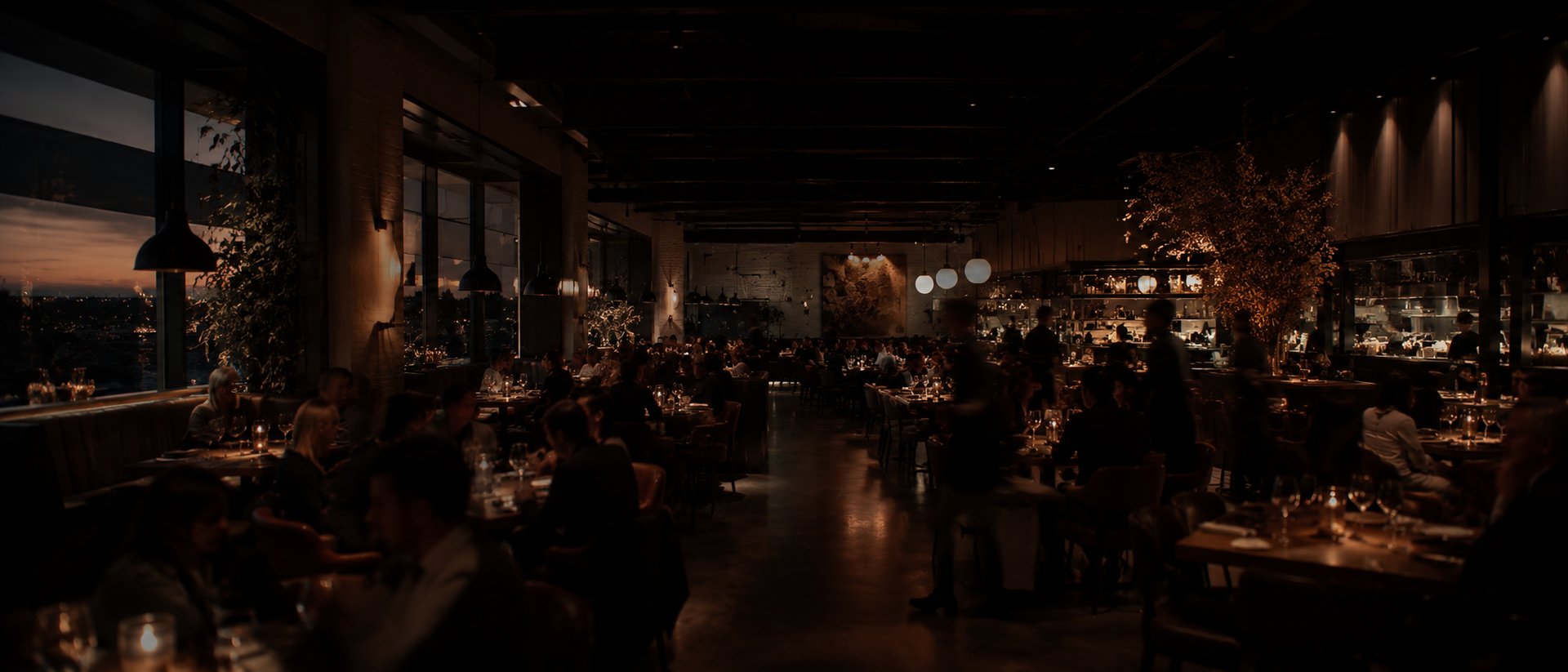 A warm, full dining room at dusk